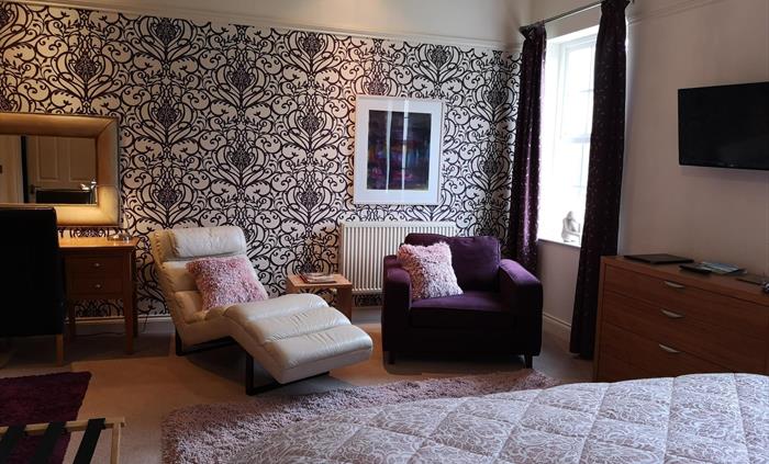 The Cherry Suite has a super-king size bed which can be converted to twin beds, a comfortable seating area. a flat screen smart TV and tea/coffee maki